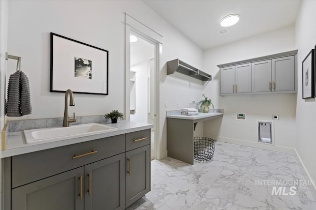 clothes washing area featuring sink, hookup for a washing machine, electric dryer hookup, and cabinets