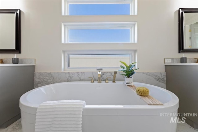 bathroom with vanity and a washtub