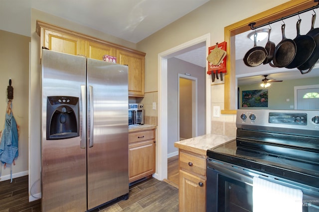 kitchen featuring stainless steel appliances, light countertops, dark wood-type flooring, decorative backsplash, and ceiling fan