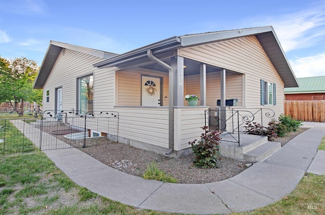 view of front of property with a porch and fence