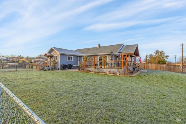 rear view of house featuring a yard