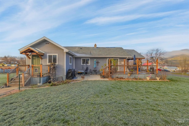 back of house with a patio area and a yard