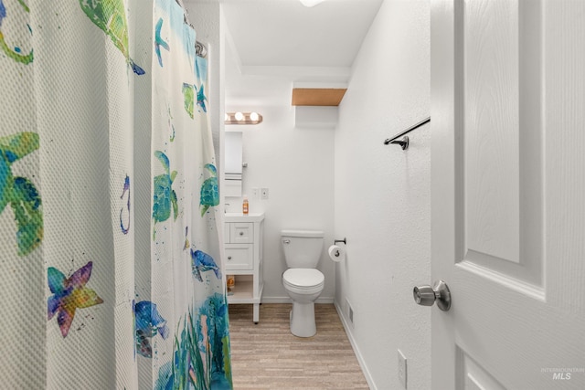 bathroom with hardwood / wood-style floors, toilet, and vanity