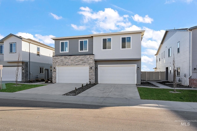 view of front facade featuring concrete driveway, an attached garage, and stone siding