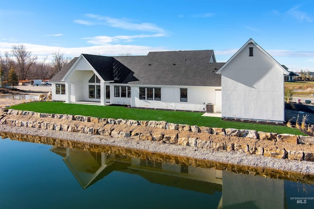 rear view of property with a yard, a water view, and central AC unit