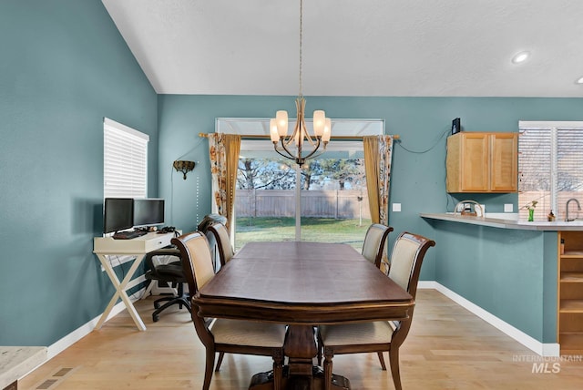 dining space featuring light hardwood / wood-style flooring, a chandelier, and sink