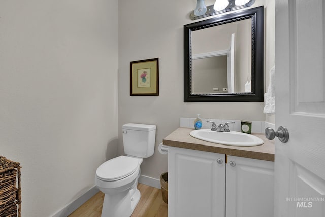 bathroom with hardwood / wood-style floors, vanity, and toilet