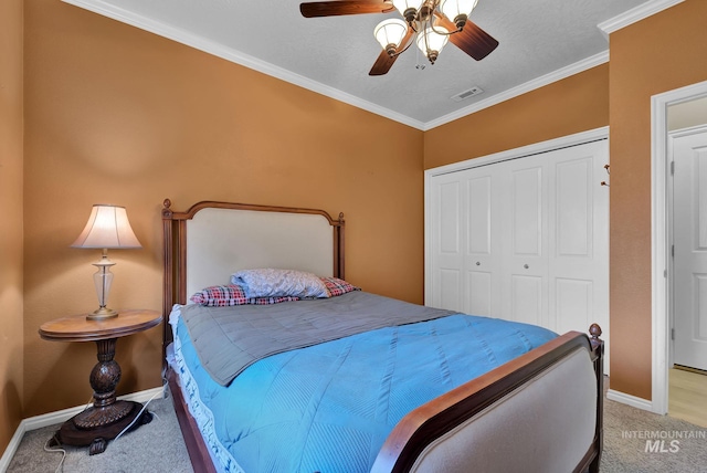 bedroom with carpet flooring, ceiling fan, ornamental molding, a textured ceiling, and a closet