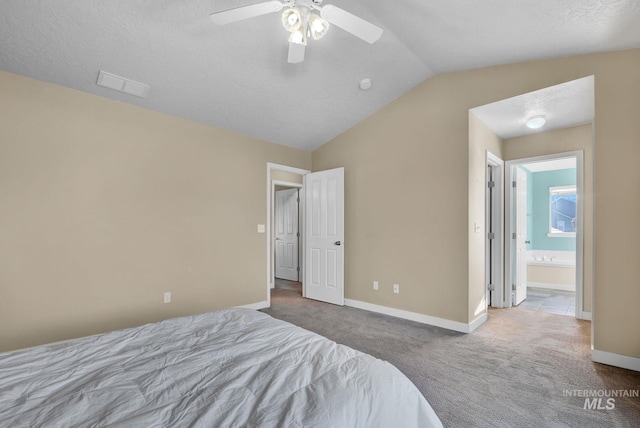 bedroom featuring carpet, ensuite bath, a textured ceiling, ceiling fan, and lofted ceiling