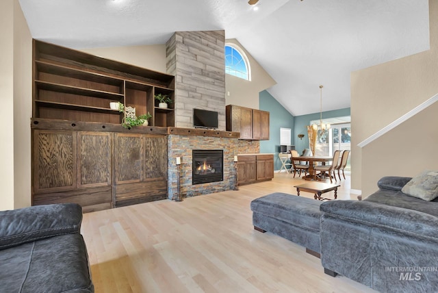 living room with a wealth of natural light, a fireplace, high vaulted ceiling, and light wood-type flooring