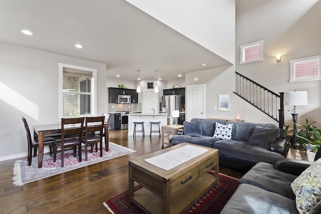 living room with baseboards, stairway, dark wood-style flooring, and recessed lighting