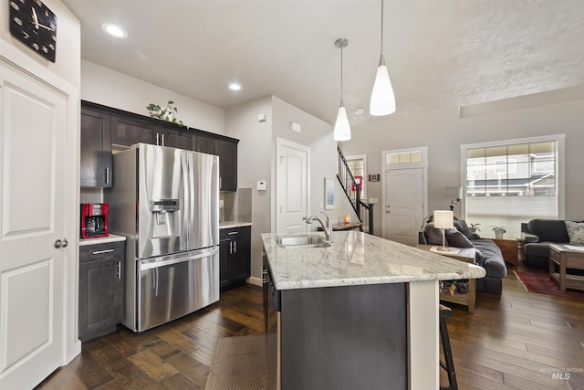 kitchen with open floor plan, stainless steel refrigerator with ice dispenser, a sink, and dark wood finished floors