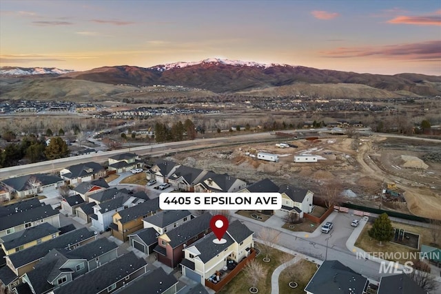 aerial view at dusk featuring a residential view and a mountain view