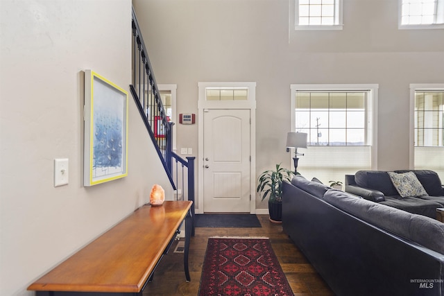 living room with dark wood-style flooring, plenty of natural light, and stairway