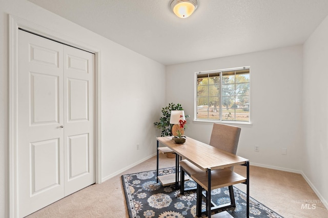 home office featuring light carpet and baseboards