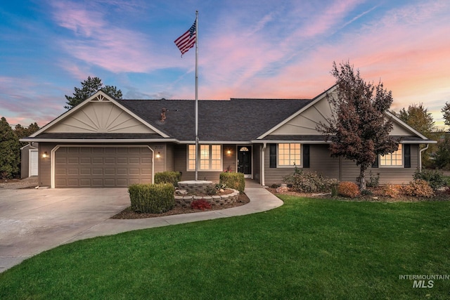 ranch-style home featuring a garage, a yard, and driveway