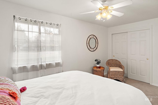 carpeted bedroom with ceiling fan and a closet