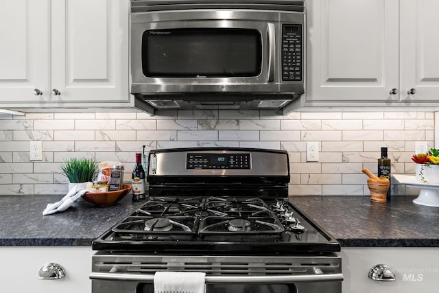 kitchen featuring stainless steel appliances, dark countertops, and white cabinets