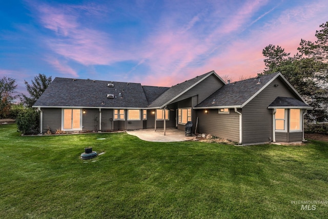 rear view of house featuring a patio and a lawn