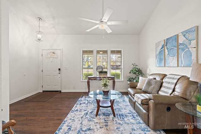 living room featuring lofted ceiling, ceiling fan, baseboards, and dark wood-type flooring