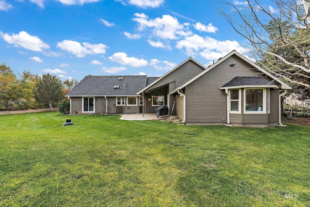 back of house featuring a lawn and a patio area