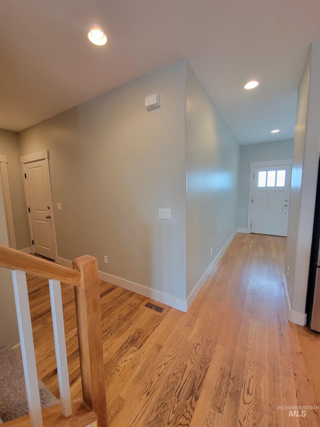 corridor with baseboards, visible vents, recessed lighting, and light wood-style floors