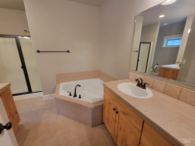 bathroom with a shower stall, a garden tub, and vanity