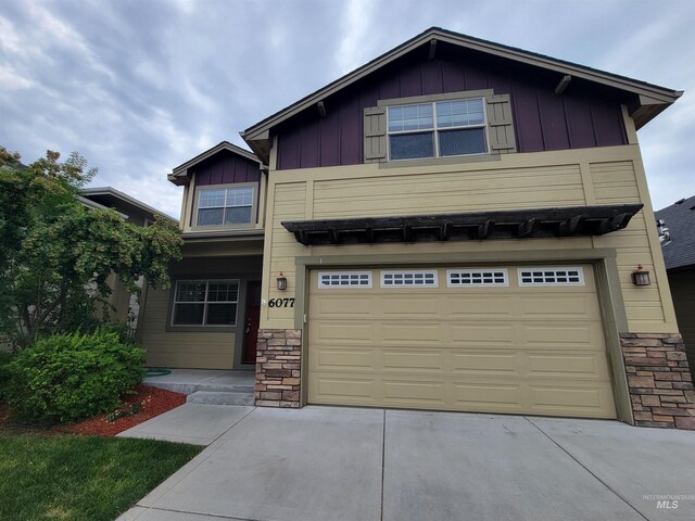 craftsman inspired home with concrete driveway, an attached garage, stone siding, and board and batten siding