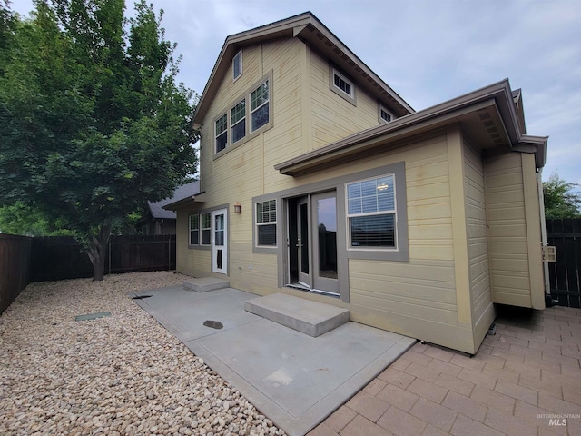 rear view of property featuring a fenced backyard and a patio
