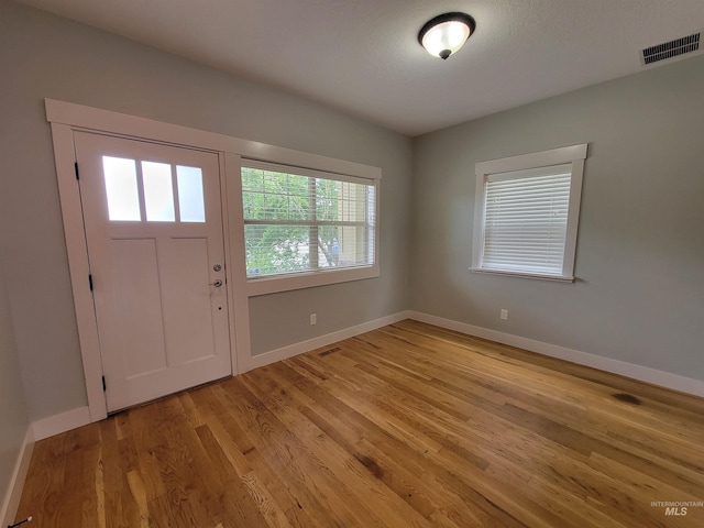 entrance foyer with baseboards, light wood finished floors, and visible vents
