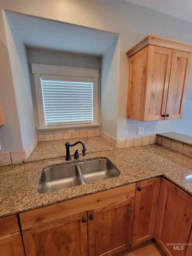 kitchen featuring light stone counters and a sink