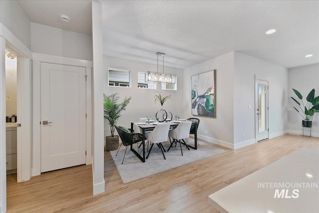 dining space featuring baseboards, a chandelier, recessed lighting, light wood-style floors, and a textured ceiling