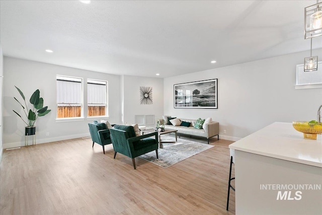 living area with recessed lighting, light wood-type flooring, and baseboards