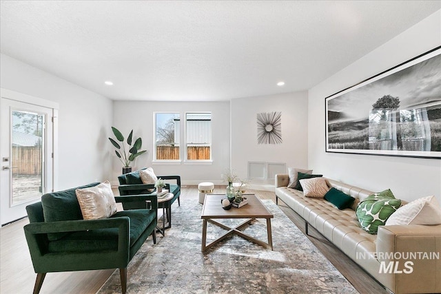 living area with recessed lighting, baseboards, and wood finished floors