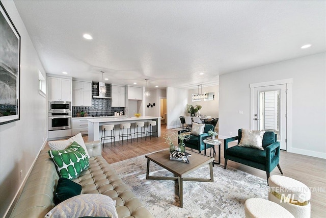 living area with recessed lighting, baseboards, and light wood finished floors