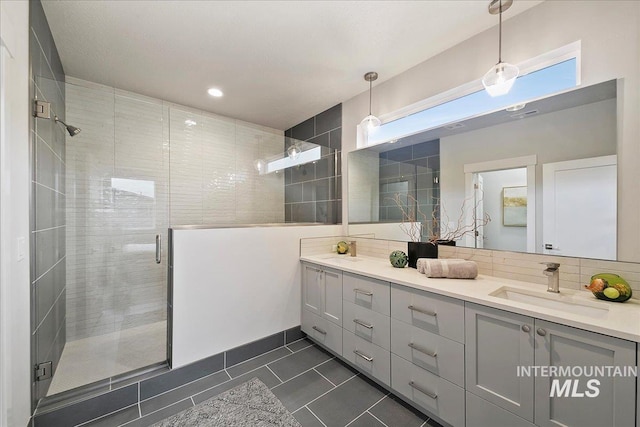 full bathroom with a sink, a stall shower, double vanity, and tile patterned floors