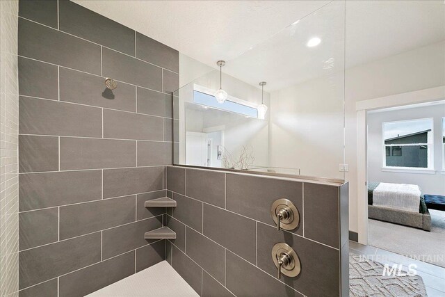 ensuite bathroom featuring connected bathroom and tiled shower