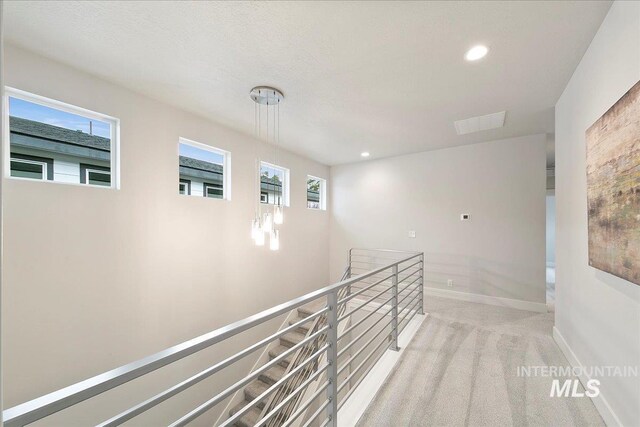 hall featuring visible vents, baseboards, carpet floors, an upstairs landing, and recessed lighting