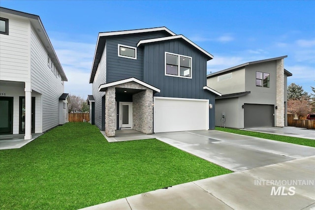 view of front of property featuring a front lawn, driveway, fence, board and batten siding, and an attached garage