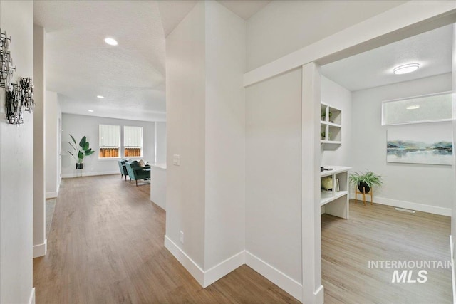 hall with baseboards and light wood-type flooring