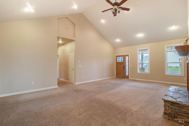 spare room with light colored carpet, ceiling fan, and high vaulted ceiling