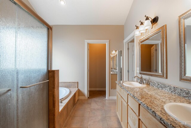 bathroom featuring double sink vanity, tile floors, and tiled tub