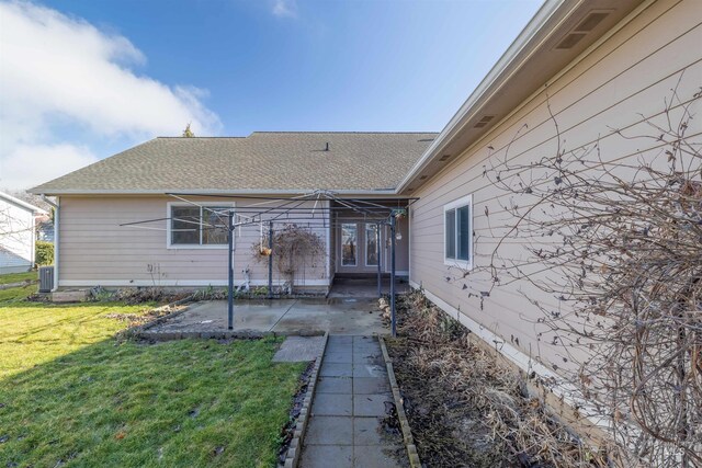 rear view of property with a lawn, central AC, and a patio