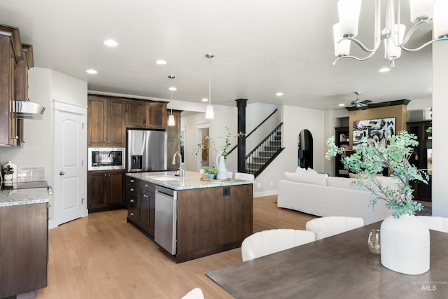 5826 E Playwright St, Boise, ID 83716 - kitchen featuring appliances with stainless steel finishes, light wood-style flooring, wall chimney range hood, dark brown cabinetry, and recessed lighting