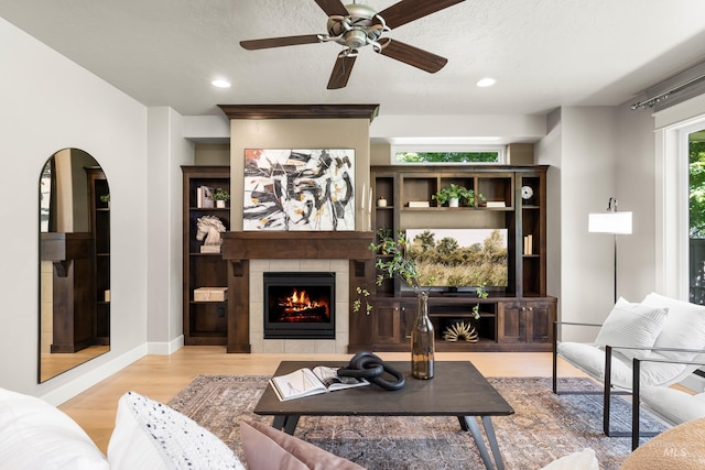 5826 E Playwright St, Boise, ID 83716 - living area with wood finished floors, a fireplace, a ceiling fan, recessed lighting, and arched walkways