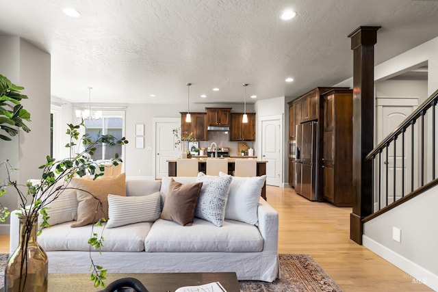 5826 E Playwright St, Boise, ID 83716 - living room featuring light wood-type flooring, a chandelier, recessed lighting, stairway, and a textured ceiling