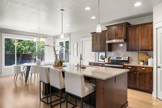 5826 E Playwright St, Boise, ID 83716 - kitchen featuring stainless steel electric range oven, under cabinet range hood, recessed lighting, light wood-style floors, and plenty of natural light