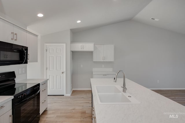 kitchen featuring sink, black appliances, lofted ceiling, and light hardwood / wood-style floors