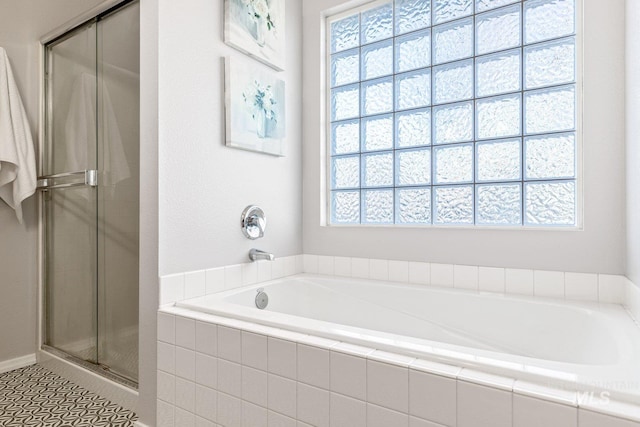 bathroom featuring plus walk in shower and a wealth of natural light