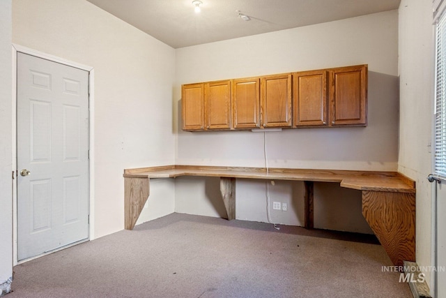 unfurnished office featuring light carpet and built in desk